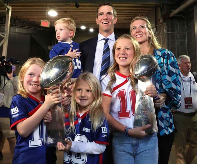 Eli Manning of the New York Giants with his family and the two Super Bowl trophies after his ring of honor induction ceremony during halftime of the game between the New York Giants and the Atlanta Falcons at MetLife Stadium on September 26, 2021 in East Rutherford, New Jersey