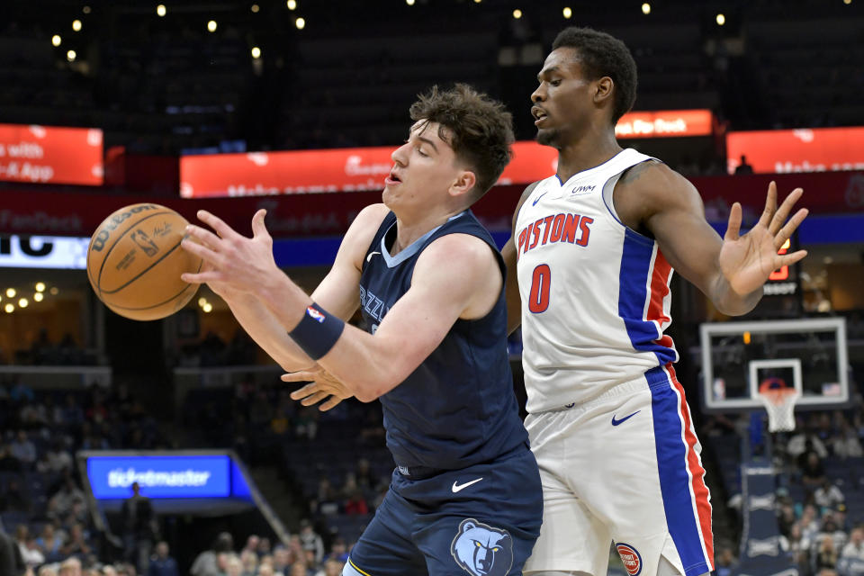 Memphis Grizzlies guard Luke Kennard, left, handles the ball against Detroit Pistons center Jalen Duren (0) in the first half of an NBA basketball game Friday, April 5, 2024, in Memphis, Tenn. (AP Photo/Brandon Dill)