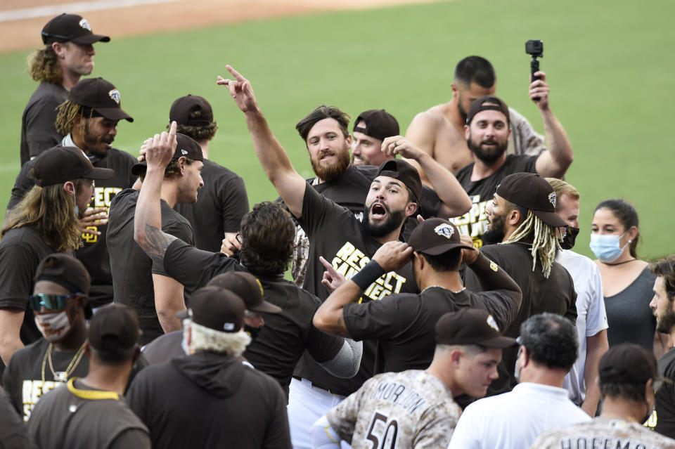 San Diego Padres shortstop Eric Hosmer, center, celebrates after the Padres beat the Seattle Mariners in a baseball game Sunday, Sept. 20, 2020, in San Diego. The Padres clinched a spot in the playoffs. (AP Photo/Denis Poroy)