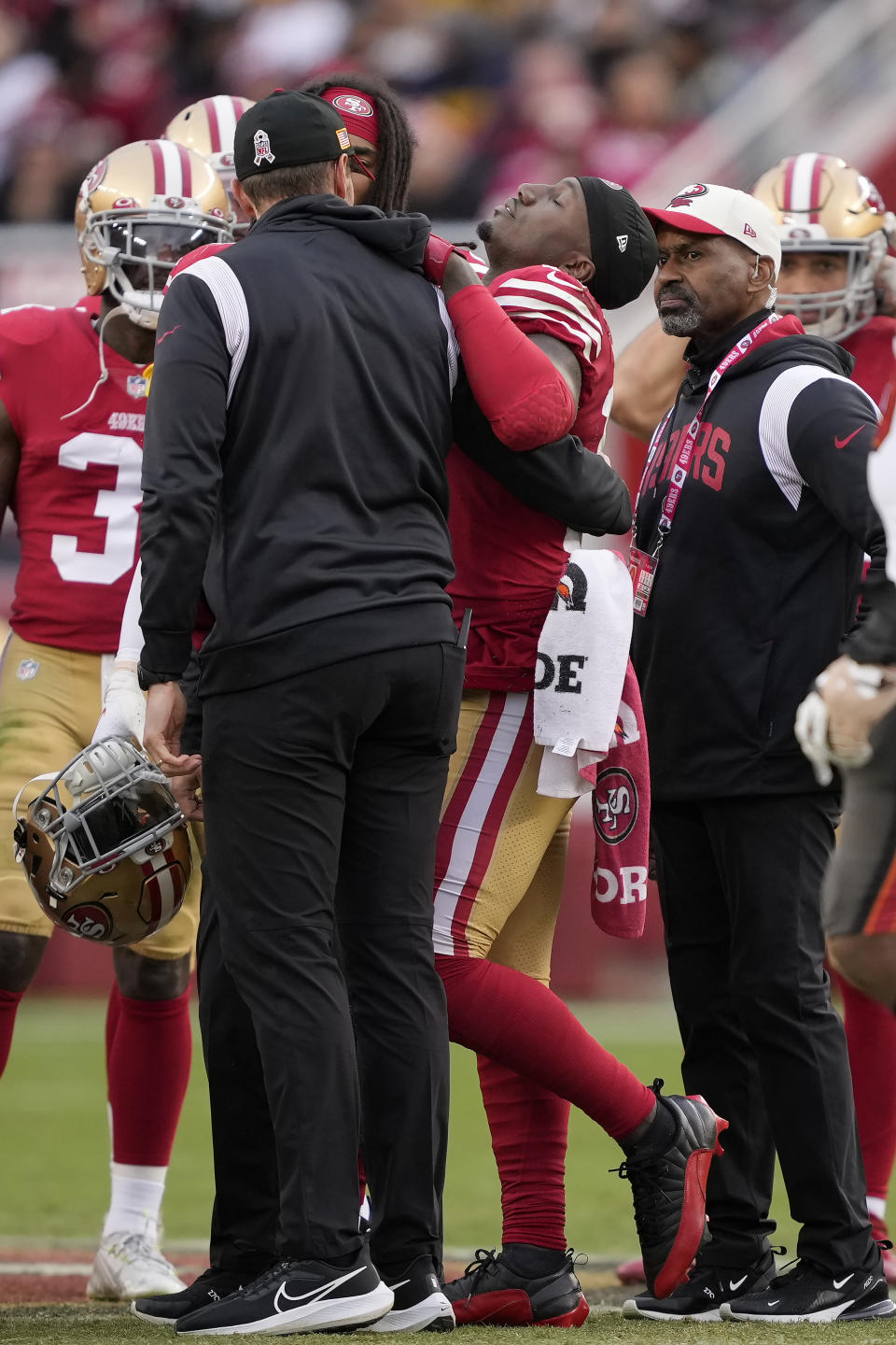 San Francisco 49ers wide receiver Deebo Samuel, middle, tries to walk off the field before being carted off during the first half of an NFL football game against the Tampa Bay Buccaneers in Santa Clara, Calif., Sunday, Dec. 11, 2022. (AP Photo/Tony Avelar)