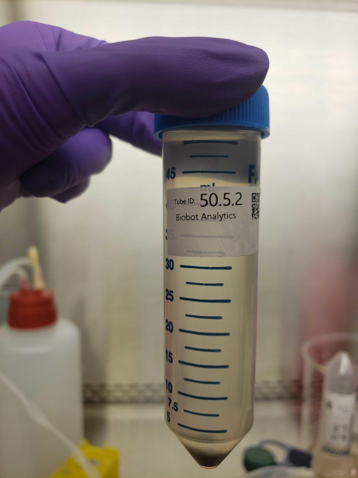 A laboratory technician for Biobot Analytics holds up a bottle containing a sample of sewage, which will be tested for COVID-19. Austin Public Health and Austin Water did not have sample kits to be able to do water surveillance for about a month.