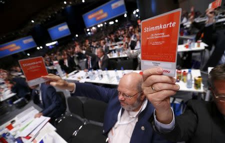 Christian Democratic Union (CDU) delegates vote on a resolution about refugees during the CDU party congress in Karlsruhe, Germany December 14, 2015. REUTERS/Ralph Orlowski