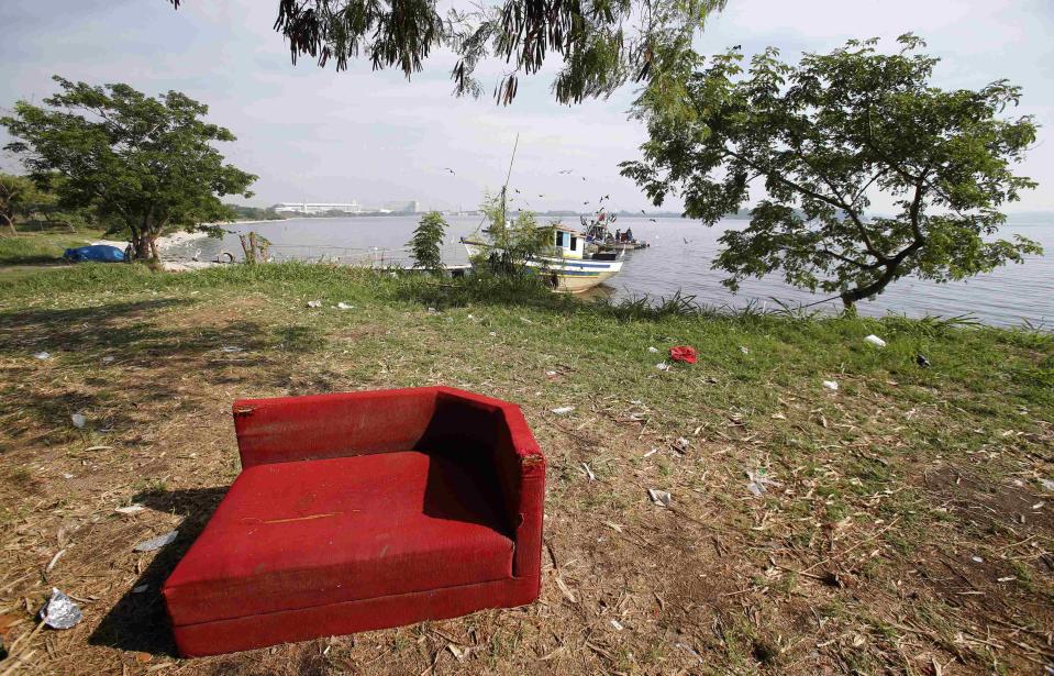 A sofa is seen near a fishing boat on Fundao beach in the Guanabara Bay in Rio de Janeiro March 13, 2014. According to the local media, the city of Rio de Janeiro continues to face criticism locally and abroad that the bodies of water it plans to use for competition in the 2016 Olympic Games are too polluted to host events. Untreated sewage and trash frequently find their way into the Atlantic waters of Copacabana Beach and Guanabara Bay - both future sites to events such as marathon swimming, sailing and triathlon events. REUTERS/Sergio Moraes (BRAZIL - Tags: ENVIRONMENT SPORT OLYMPICS)