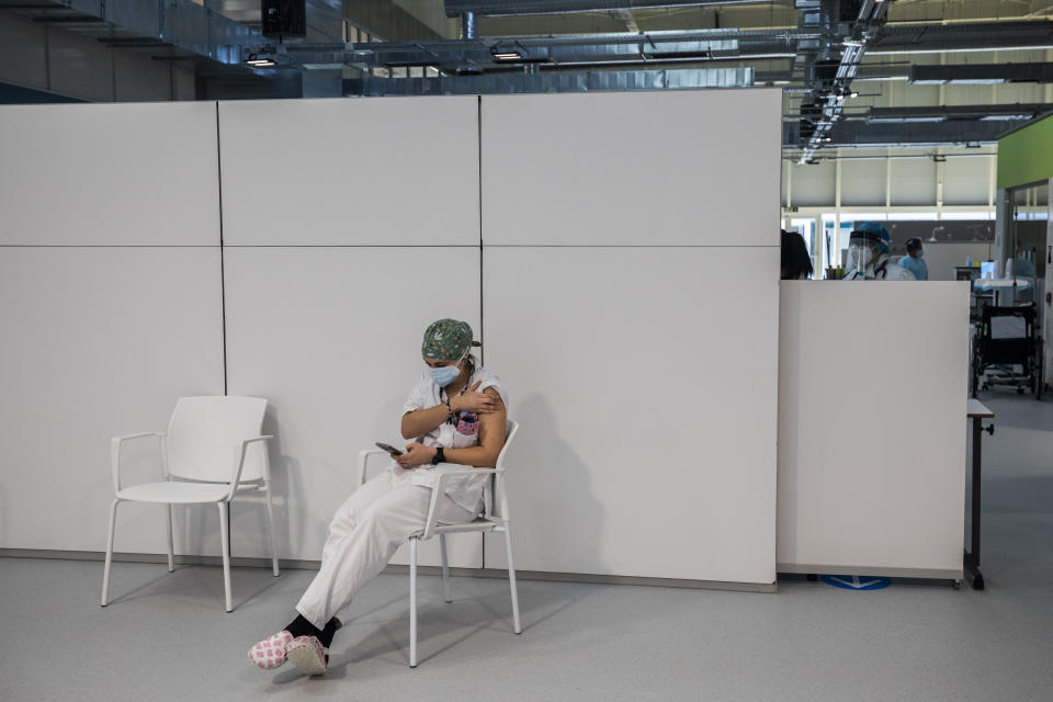 Spanish nurse Irene Vazquez, 28, pauses after receiving the second dose of the Pfizer-BioNTech COVID-19 vaccine at the Nurse Isabel Zendal Hospital in Madrid, Spain, Monday, Feb. 1, 2021. (AP Photo/Bernat Armangue)