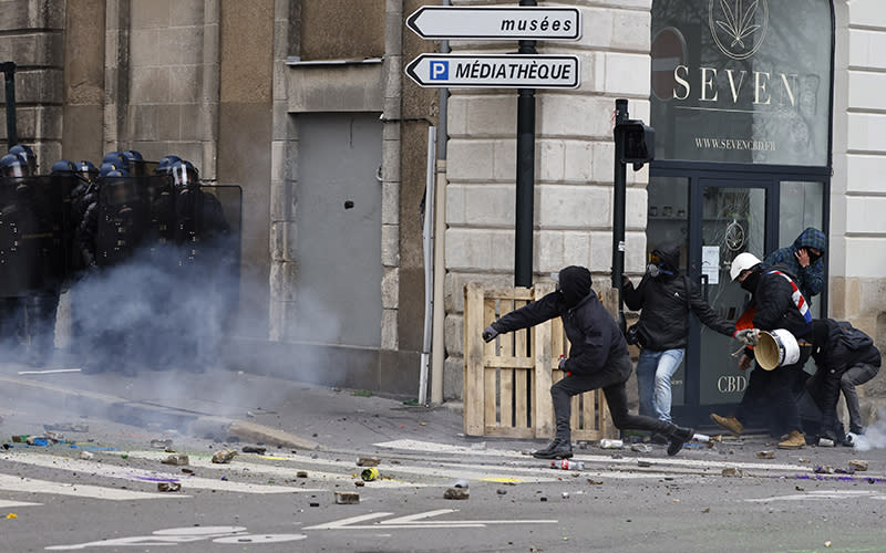 Youths clash with riot police officers during a protest in Nantes, western France