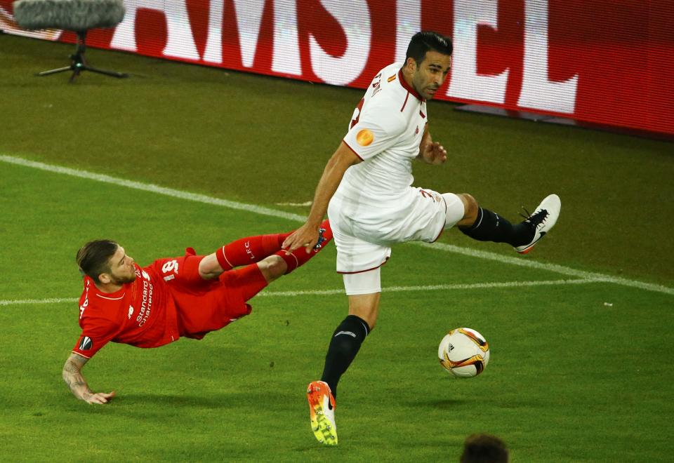 Adil Rami (Sevilla) defiende un intento de ataque de Alberto Moreno (Liverpool)
