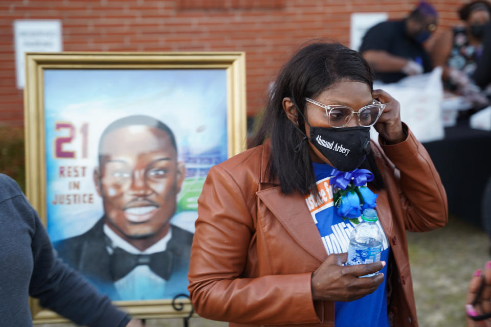 Wanda Cooper-Jones, the mother of Ahmaud Arbery, stands in front of a painting of her son after a candlelight vigil for him on Tuesday at the New Springfield Baptist Church in Waynesboro, Georgia. Arbery was shot and killed while jogging near Brunswick, Georgia, a year ago on Tuesday after being chased by two white men. (Photo: Sean Rayford/Getty Images)