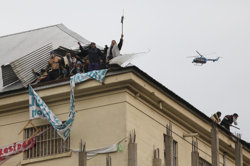 A police helicopter flies over rioting inmates protesting from the roof of Villa Devoto prison in Buenos Aires, Argentina, Friday, April 24, 2020. Inmates complain authorities are not doing enough to prevent the spread of coronavirus inside the prison. (AP Photo/Natacha Pisarenko)