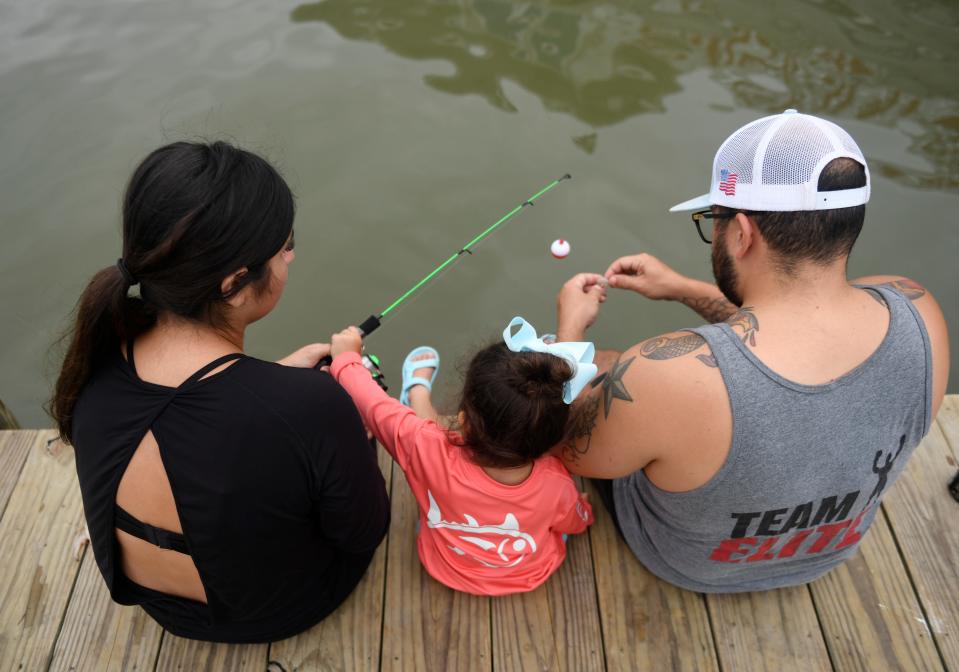 Two-year-old Nayeli Marmolejo, center, fishes with her parents at the Deep Sea Roundup's Piggy Perch, Saturday, July 10, 2021, in Port Aransas. Marmolejo caught five fish.