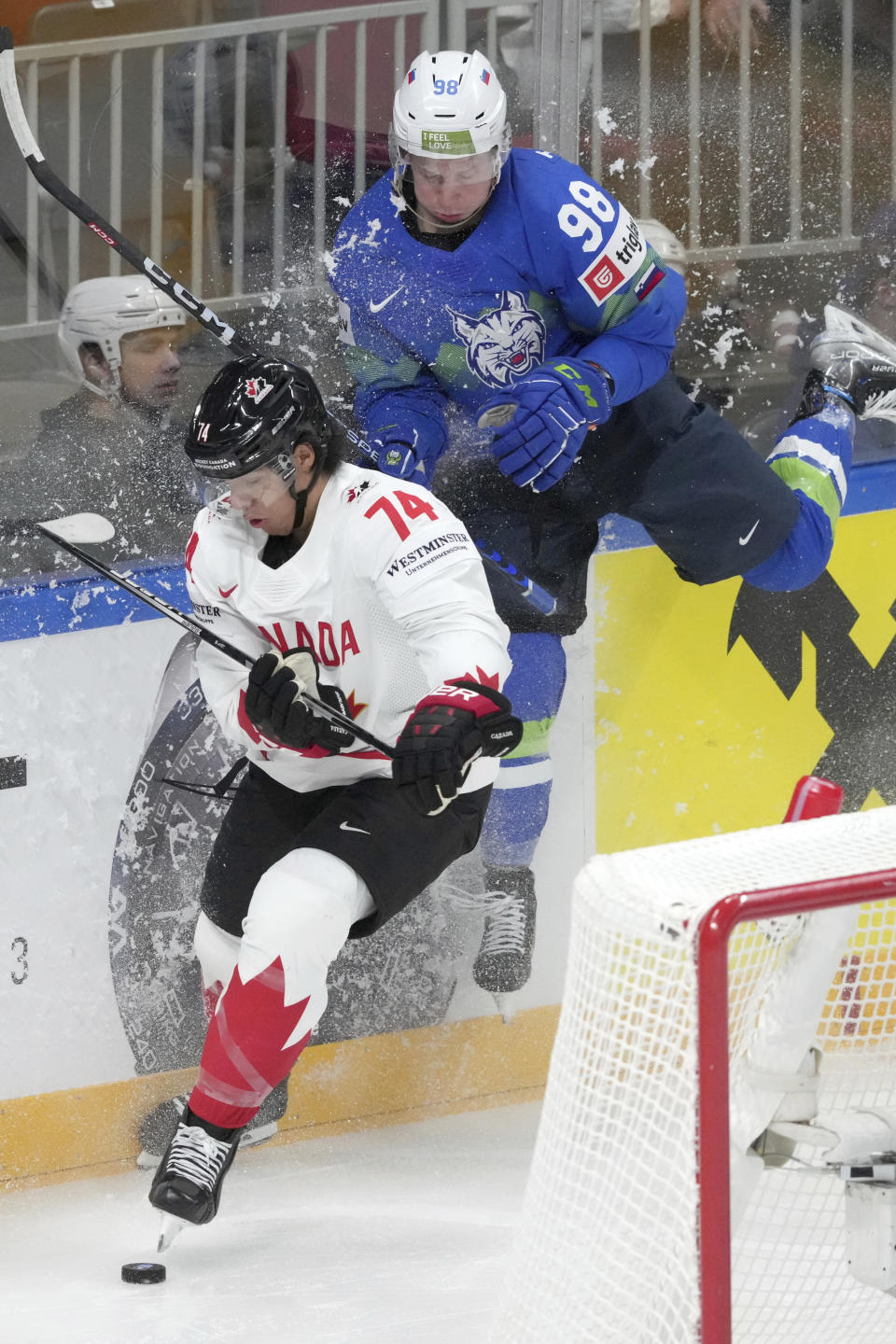 Blaz Tomazevic of Slovenia, right, fights for a puck with Ethan Bear of Canada during the group B match between Slovenia and Canada at the ice hockey world championship in Riga, Latvia, Sunday, May 14, 2023. (AP Photo/Roman Koksarov)