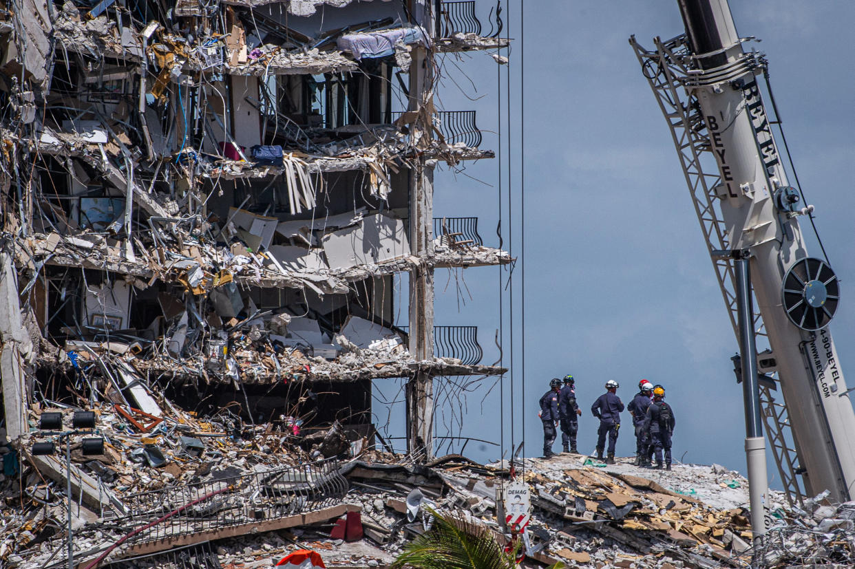 Members of the South Florida Urban Search and Rescue team look for possible survivors in the partially collapsed Champlain Towers South condo building in Surfside, Fla. (Giorgio Viera / AFP via Getty Images)