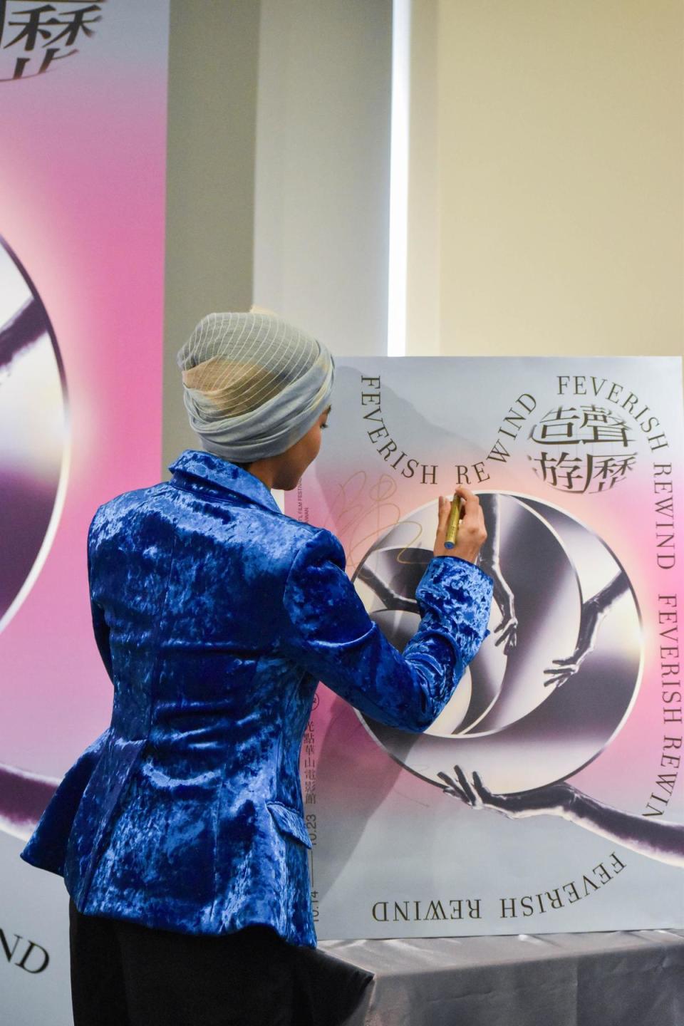 阿爆為影展海報簽名，2022女性影展正式起跑。（女性影展提供）