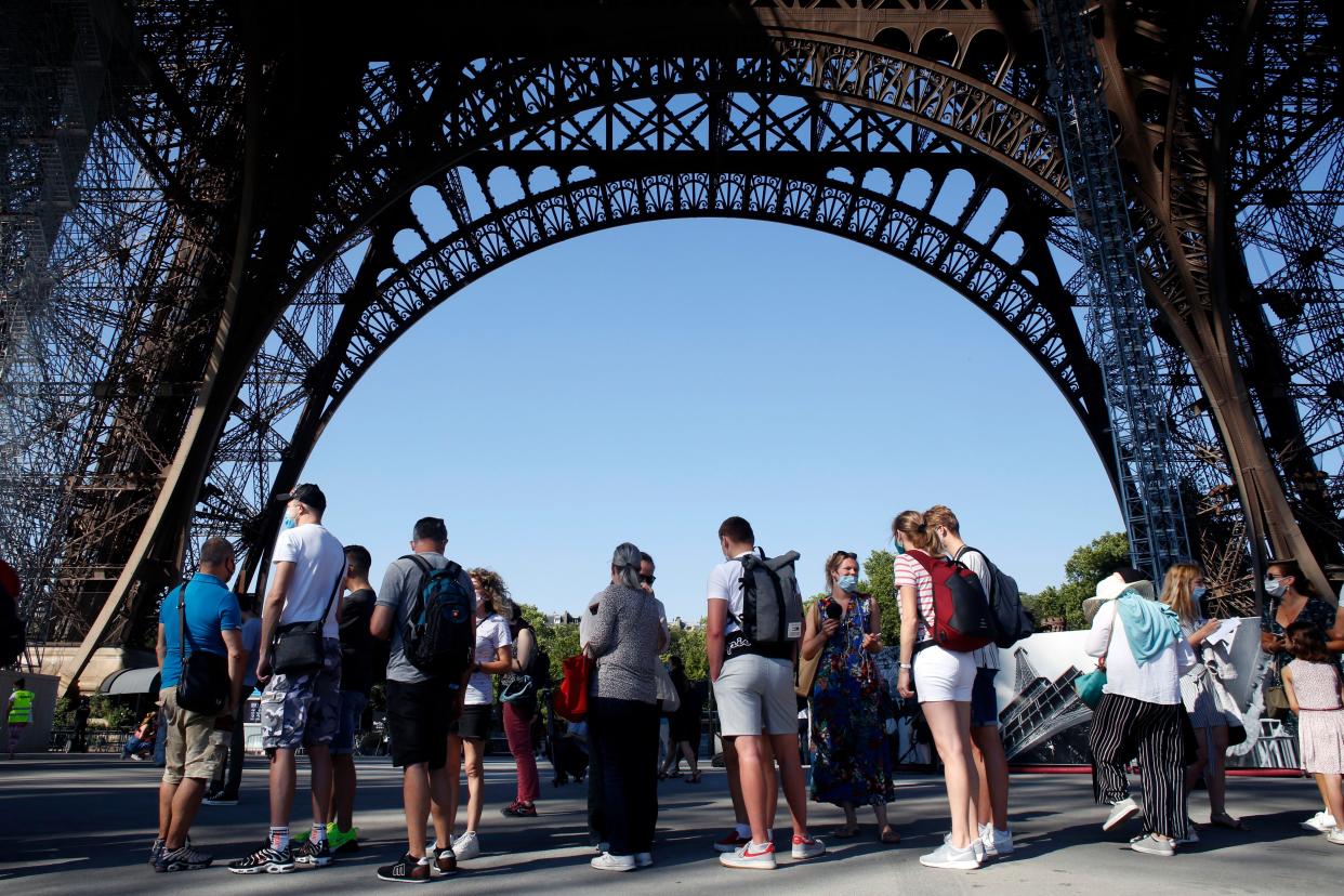 People line up prior to visit the Eiffel Tower in Paris on June 25, 2020. The Eiffel Tower deemed safe to reopen on Thursday after the coronavirus pandemic led to the iconic landmark's longest closure since World War II.
