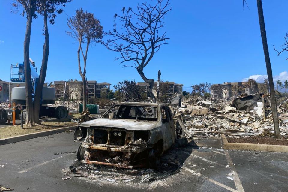 A burned cars sits among destroyed buildings in the aftermath of a wildfire in Lahaina, western Maui, Hawaii.