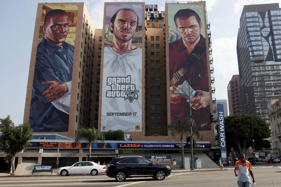 FILE - This Sept. 10, 2013 file photo shows billboards for "Grand Theft Auto V " billboard on a hotel in Los Angeles. On Friday, July 12, 2019, The Associated Press reported on stories circulating online incorrectly asserting that a video shows an attempted terrorist attack in Algeria where an airliner on its landing approach narrowly misses a fuel tanker that has pulled into its path. The fabricated clip was taken from the video game "Grand Theft Auto V" and then circulated with false captions. (AP Photo/Nick Ut, File)