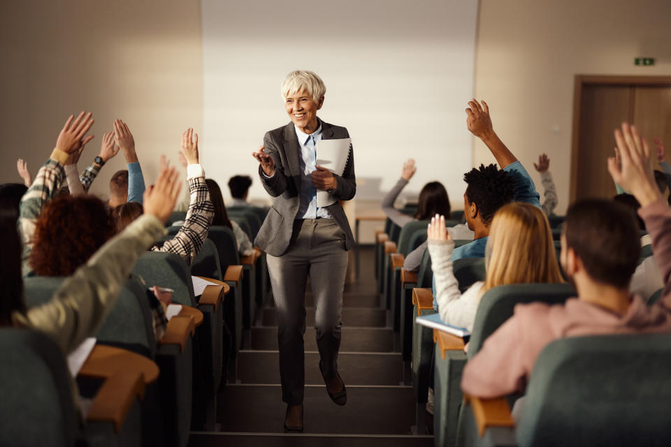 college professor walking up the aisle of her lecture room