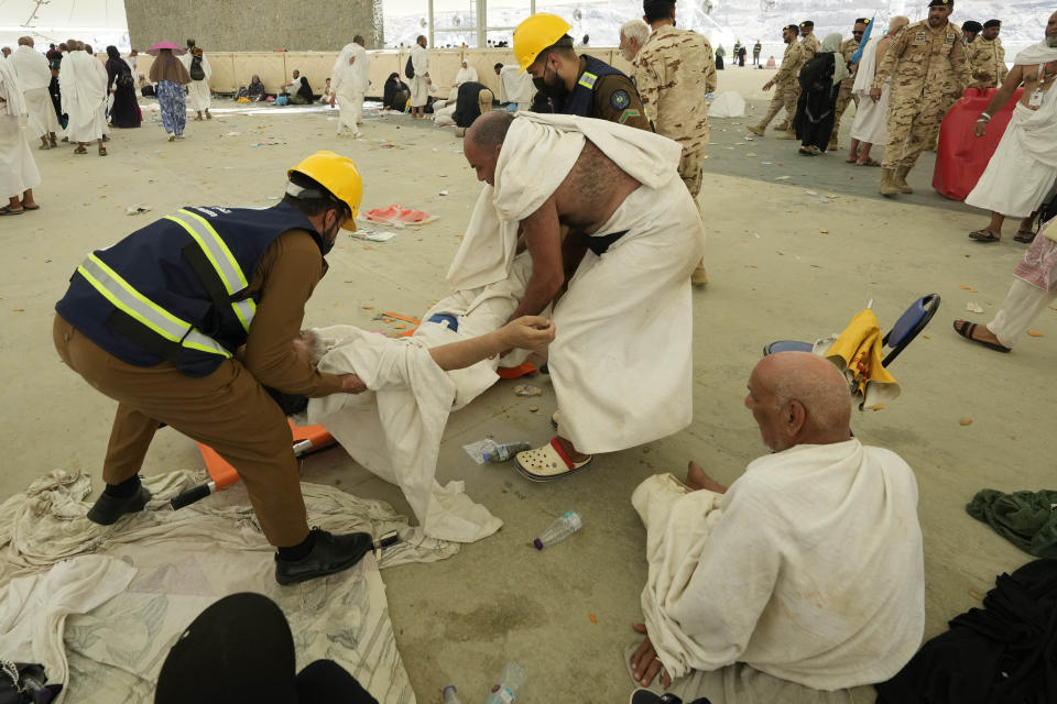 Paramedics carry a muslim pilgrim for a medical check after he fell down due to a heat stroke at pillars, in Mina, near the holy city of Mecca, Saudi Arabia, Sunday, June 16, 2024. Masses of pilgrims on Sunday embarked on a symbolic stoning of the devil in Saudi Arabia. The ritual marks the final days of the Hajj, or Islamic pilgrimage, and the start of the Eid al-Adha celebrations for Muslims around the world. (AP Photo/Rafiq Maqbool)