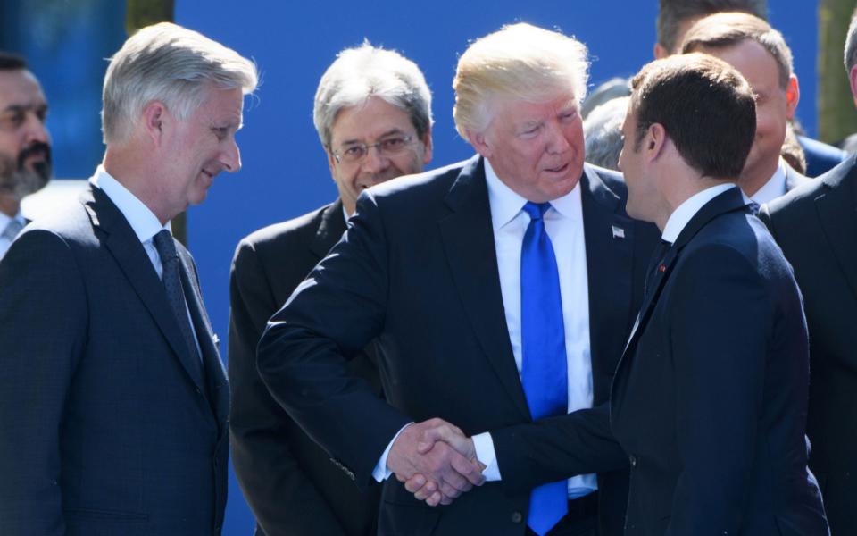 Donald Trump and Emmanuel Macron shake hands vigorously  - Credit: CHRISTOPHE LICOPPE/AFP