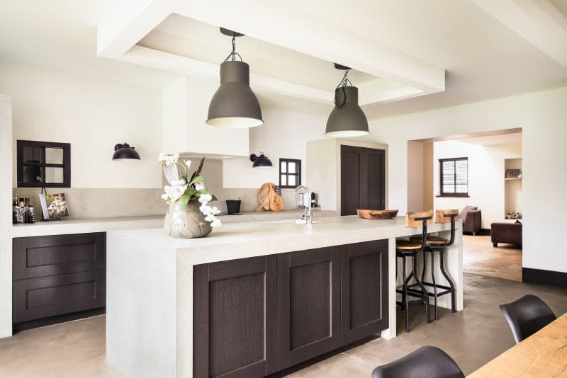 Eindhoven, The Netherlands - December 19, 2015: Bright modern kitchen interior with island, sink, and cabinets in new luxury home.