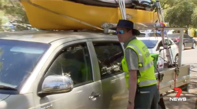 A ranger looks at the dog inside the vehicle. Source: 7 News