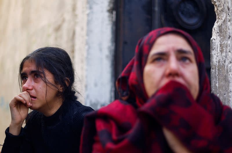 Una niña y una mujer palestinas miran hacia el lugar de un ataque israelí contra una casa, tras expirar una tregua temporal entre Hamás e Israel, en Jan Yunis