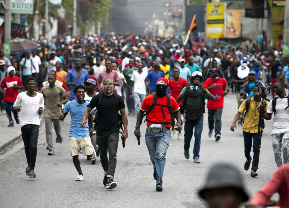 Armed off-duty police officers protest over police pay and working conditions, in Port-au-Prince, Haiti, Sunday, Feb. 23, 2020. Off-duty police officers and their supporters exchanged fire for nearly two hours with members of the newly reconstituted Haitian army in front of the national palace. (AP Photo/Dieu Nalio Chery)