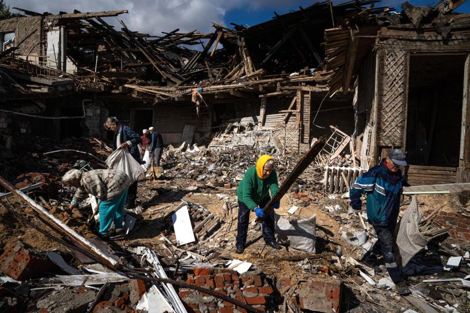 Local residents collect wood for heating from a destroyed school where Russian forces were based, in the recently retaken area of Izium, Ukraine (Evgeniy Maloletka/AP) (AP)