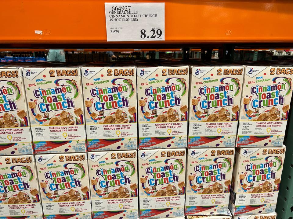 boxes of cinnamon toast crunch in rows under an orange beam with a $8.29 costco price sign