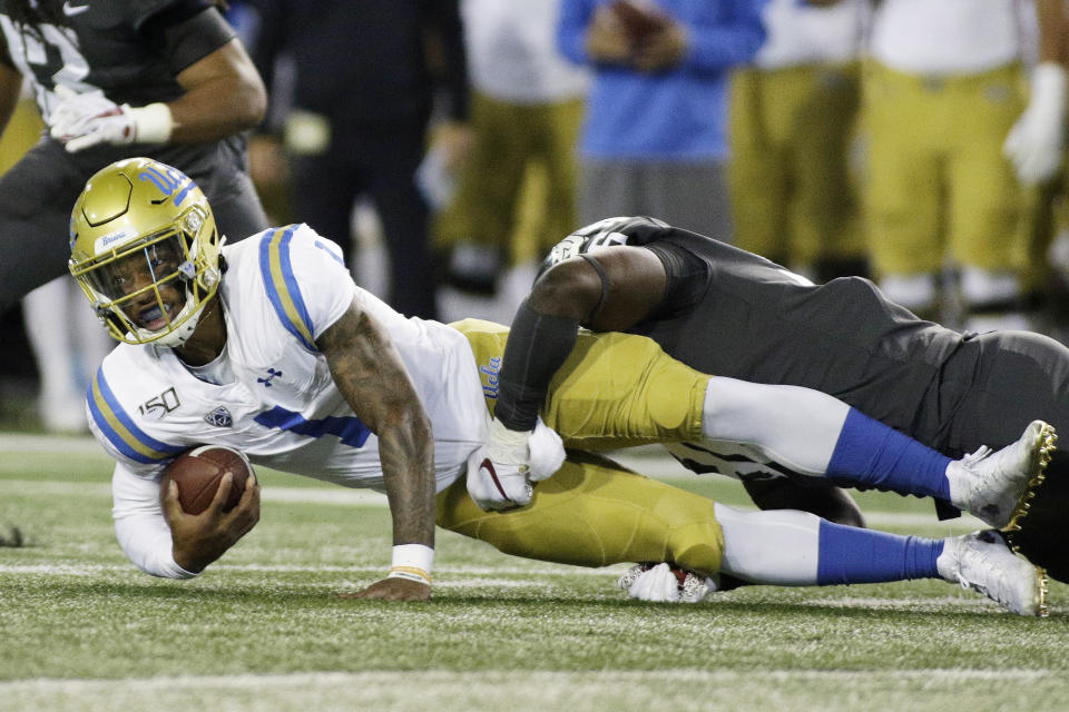 Washington State defensive lineman Cosmas Kwete, right, tackles UCLA quarterback Dorian Thompson-Robinson during the first half of an NCAA college football game in Pullman, Wash., Saturday, Sept. 21, 2019. (AP Photo/Young Kwak)