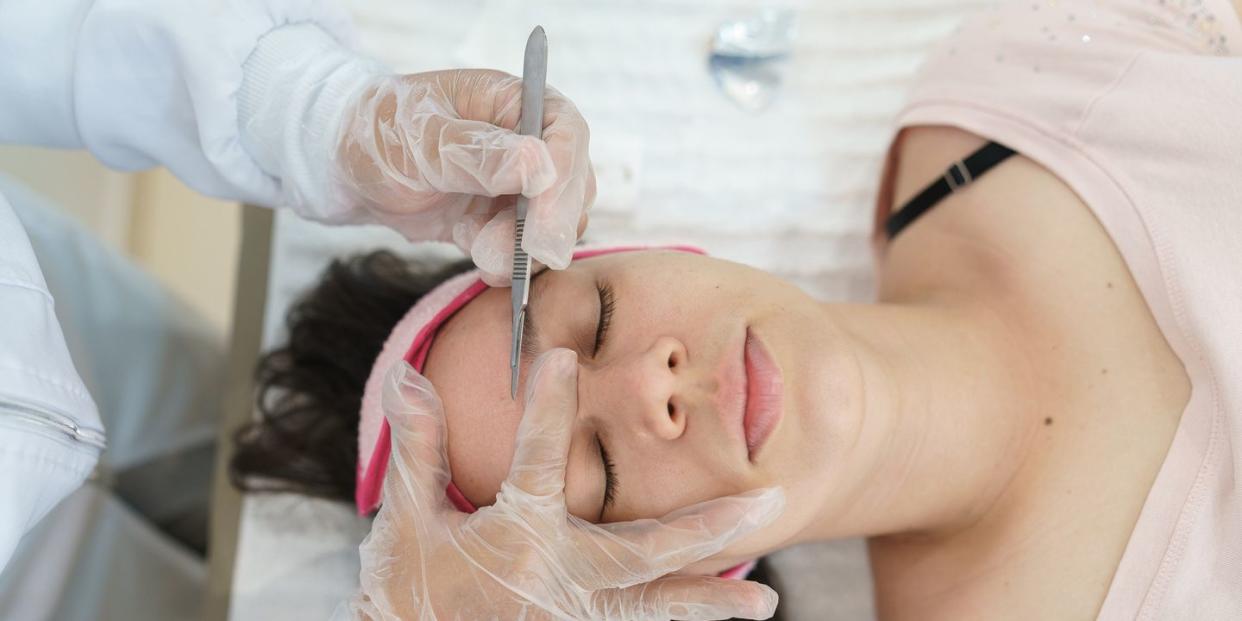 beautician performing dermaplaning treatment