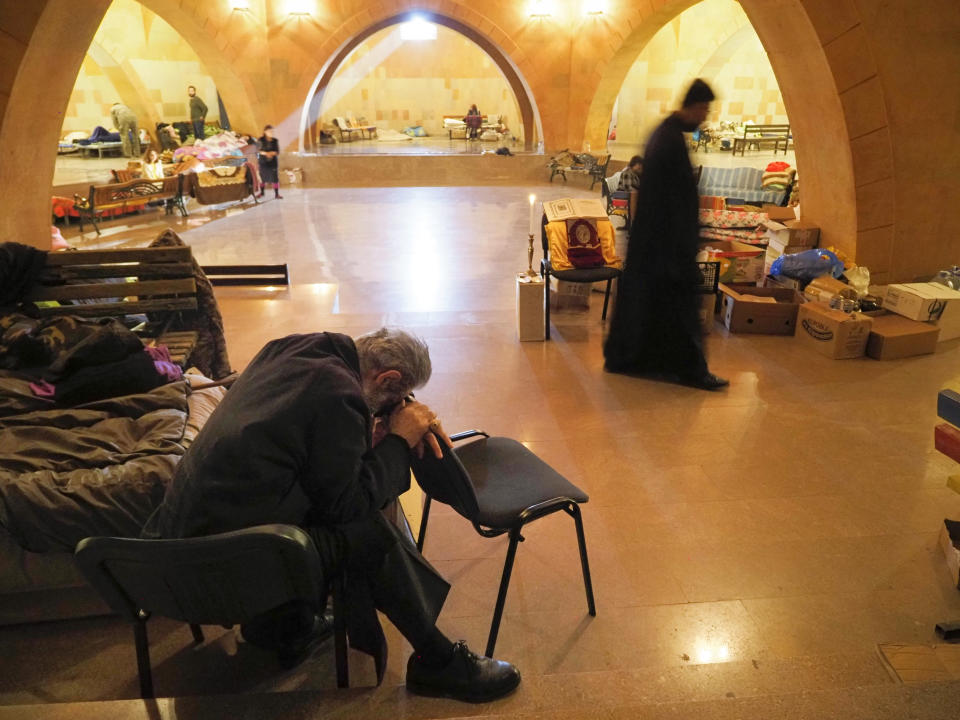 People and priests take refuge in an improvised bomb shelter in the separatist region of Nagorno-Karabakh, Friday, Oct. 30, 2020. The Azerbaijani army has closed in on a key town in the separatist territory of Nagorno-Karabakh following more than a month of intense fighting. (AP Photo)