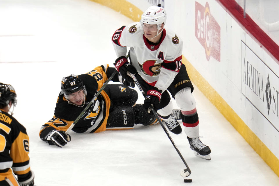 Ottawa Senators' Tim Stutzle (18) comes away with the puck after colliding with Pittsburgh Penguins' Sidney Crosby (87) during the third period of an NHL hockey game in Pittsburgh, Saturday, Oct. 28, 2023. (AP Photo/Gene J. Puskar)