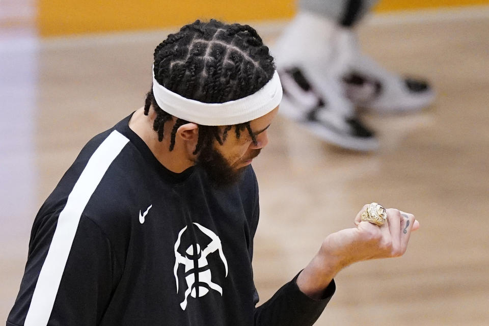 Denver Nuggets center JaVale McGee looks at his championship ring after receiving it prior to their NBA basketball game against the Los Angeles Lakers Monday, May 3, 2021, in Los Angeles. McGee was a member of the Lakers when they won the NBA Championship in 2020. (AP Photo/Mark J. Terrill)