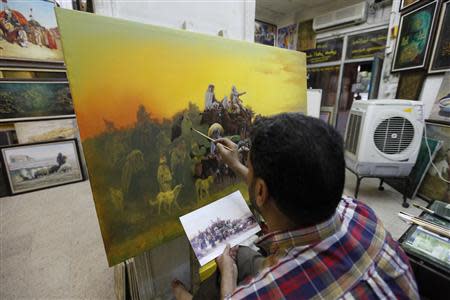 Iraqi artist Ahmed al-Khazali paints in his workshop at a gallery in Baghdad's Karrada district, September 18, 2013. Iraq has a long history in the arts, particularly sculpture, a staple of artistic life here since ancient times. REUTERS/ Thaier Al-Sudani