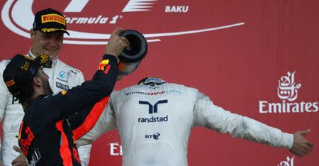 Formula One - F1 - Azerbaijan Grand Prix - Baku, Azerbaijan - June 25, 2017. Red Bull Racing Formula One driver Daniel Ricciardo of Australia celebrates his victory over second placed Mercedes' Valtteri Bottas (L) and third placed Williams' Lance Stroll. REUTERS/David Mdzinarishvili