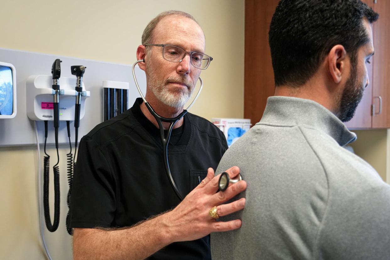 Dr. Christopher Stewart, a senior staff family physician, listens to a patient's heart and lungs at the Baylor Scott & White Clinic in Cedar Park. Stewart had a heart attack in June, even though he was not in a high-risk category.