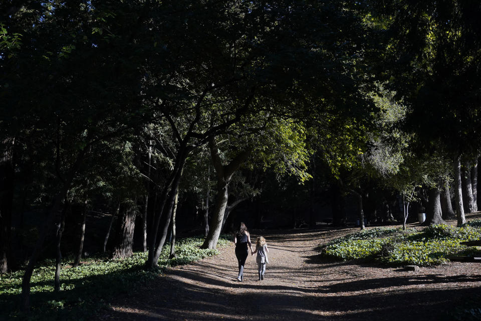 Hannah Levy walks with her daughter, Aylah, 6, at Codornices Park, a location Aylah attended as a Berkeley Forest School student, during an interview in Berkeley, Calif., Wednesday, Nov. 8, 2023. (AP Photo/Jeff Chiu)