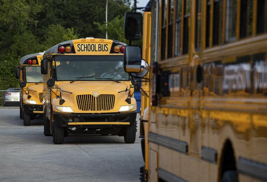 Jefferson County Public Schools school buses packed with students make their way through the Detrick Bus Compound on the first day of school Wednesday, Aug. 9, 2023, in Louisville, Ky. (Jeff Faughender/Courier Journal via AP)