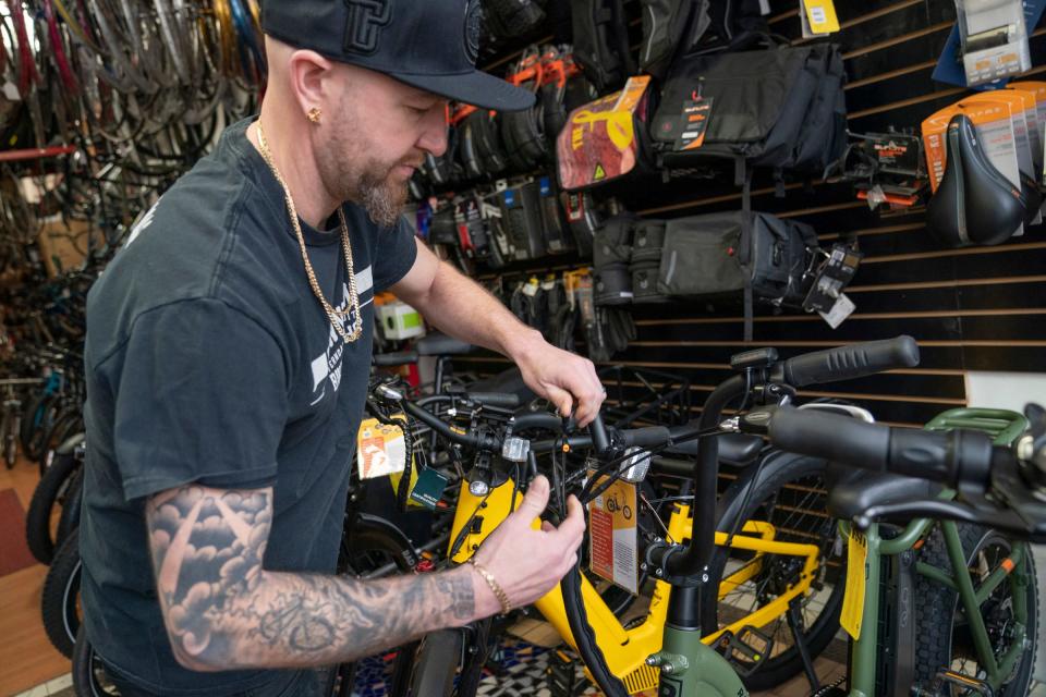 Jon Hughes, owner of the Downtown Ferndale Bike Shop, demonstrates disconnecting a cable to transform a class 2 e-bike into a class 1. Hughes also talks about the electric bikes he has for sale in his shop on Tuesday, March 19, 2024, as the Michigan DNR is proposing allowing class 1 and some class 2 e-bikes on unpaved trails in state parks.