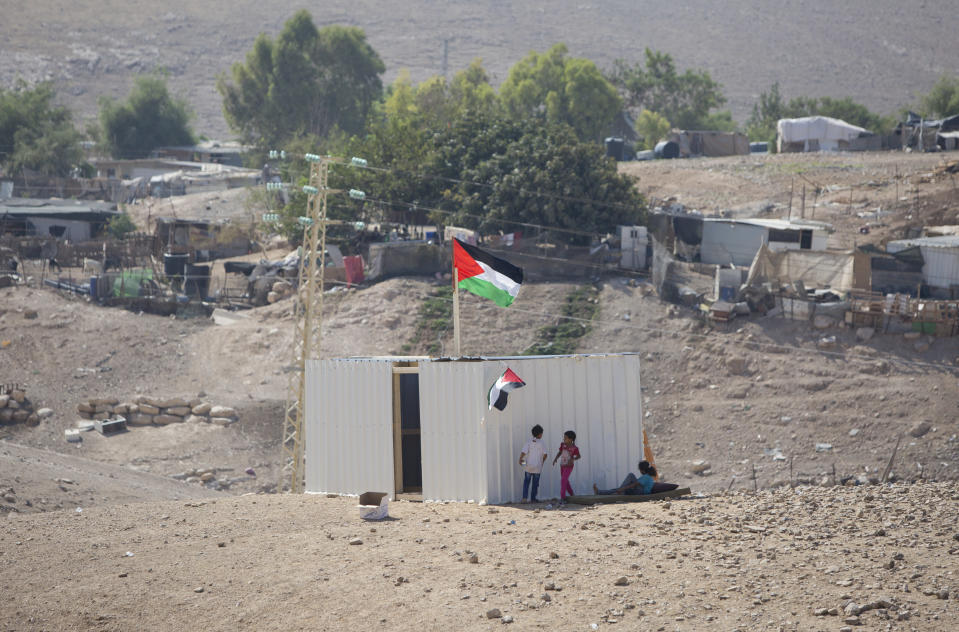 Palestinians girls sit by newly made shed in the West Bank Bedouin community of Khan al-Ahmar, Tuesday, Sept. 11, 2018. Israel says Khan al-Ahmar was illegally built and has offered to resettle residents 12 kilometers (7 miles) away. Critics say its removal is meant to make room for an Israeli settlement. Israel's Supreme Court rejected an appeal last week, paving the way for demolition. (AP Photo/Majdi Mohammed)