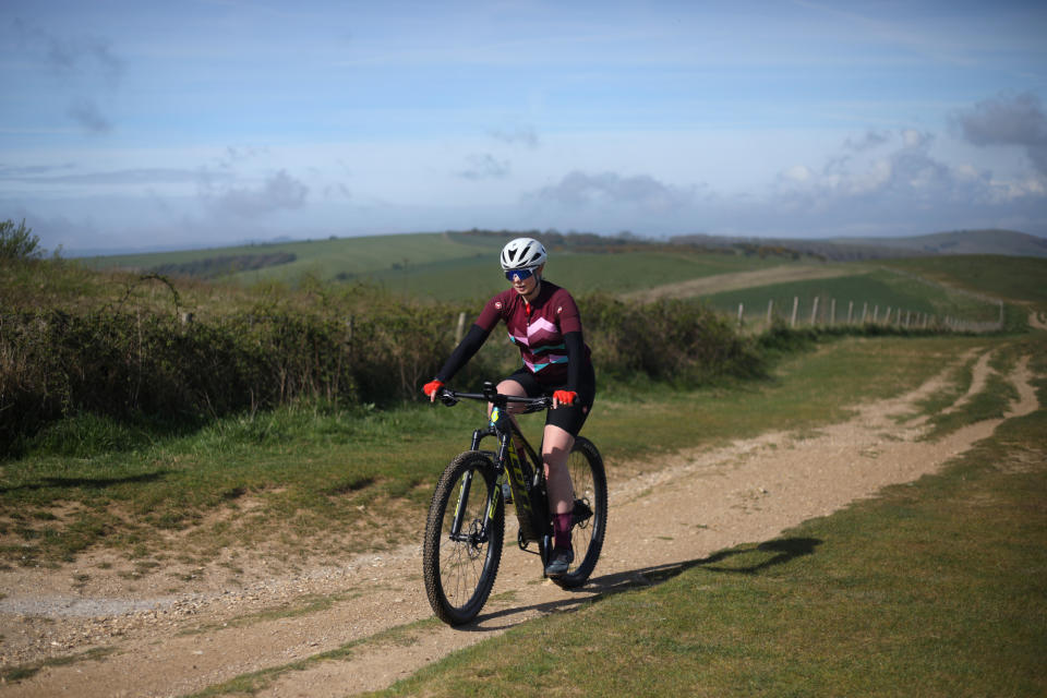 Female cyclist riding on a mountain bike while pregnant