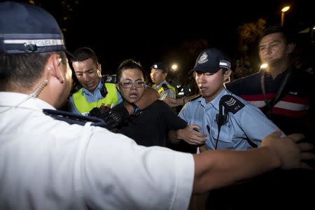 A pro-democracy activist is detained by the police during a confrontation outside the hotel where China's National People's Congress (NPC) Standing Committee Deputy General Secretary Li Fei is staying, in Hong Kong September 1, 2014. REUTERS/Tyrone Siu