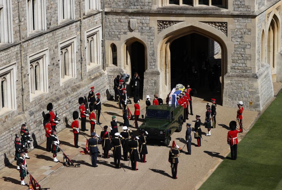 Members of the 1st Battalion Grenadier Guards place the coffin of Britain's Prince Philip onto a modified Land Rover.