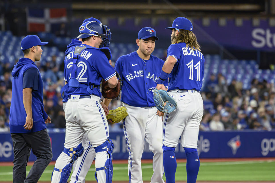 Toronto Blue Jays starting pitcher Yusei Kikuchi, second from right, is visited at the mound inning of a baseball game against the Houston Astros on Friday, April 29, 2022, in Toronto. (Christopher Katsarov/The Canadian Press via AP)