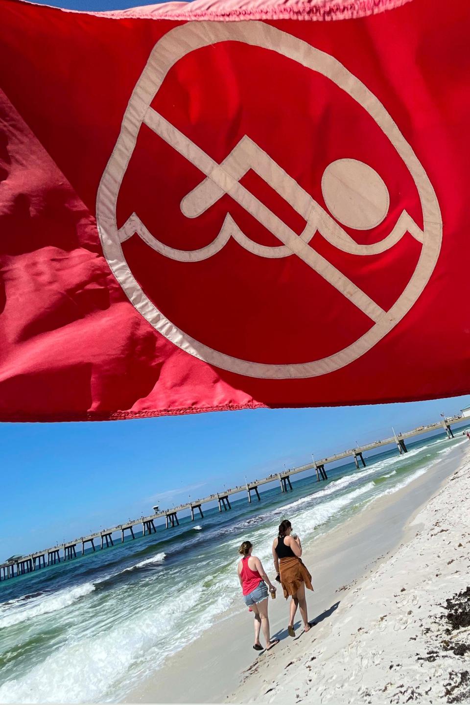 Special red flags mark a portion of the beach near The Boardwalk on Okaloosa Island where rip currents pose a threat. The red flags, which has a circle and cross over the image of a swimmer, are placed at both edges of the rip current area.