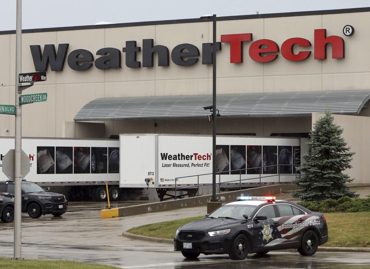 Police vehicles are parked outside the WeatherTech facility in Bolingbrook, Ill., after a shooting there.  