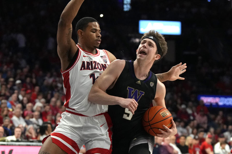 Washington guard Paul Mulcahy (9) drives on Arizona forward Keshad Johnson during the first half of an NCAA college basketball game, Saturday, Feb. 24, 2024, in Tucson, Ariz. (AP Photo/Rick Scuteri)