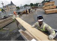 In this Wednesday, Aug. 15, 2012 photo, workers Wiil Warmbold, left, and Charles Davidson load wood planks recently cut from discarded tree trunks into a truck for the town of Secaucus, N.J., at Citilog Wednesday, in Newark, N.J. The Newark company takes unwanted trees from the so-called urban forest — parks, yards, streets and wherever else a tree might grow in a city — and turns them into furniture, flooring and other materials. (AP Photo/Mel Evans)