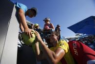 Vasek Pospisil of Canada signs autographs for fans after defeating Samuel Groth of Australia in their men's singles match at the Australian Open 2014 tennis tournament in Melbourne January 13, 2014. REUTERS/Bobby Yip (AUSTRALIA - Tags: SPORT TENNIS)