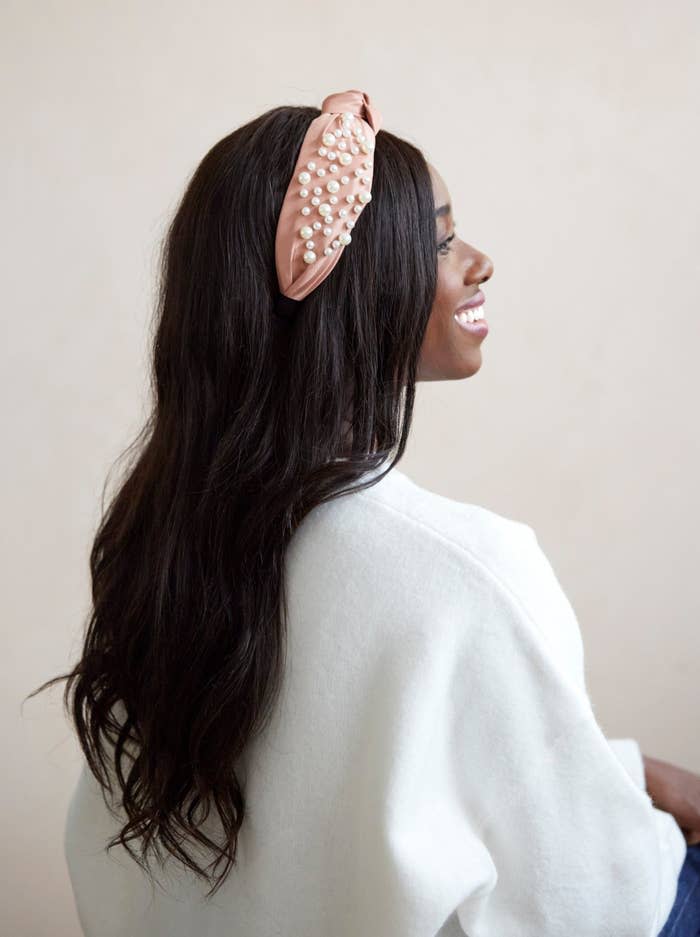 model in pink satin knotted headband with pearl accents